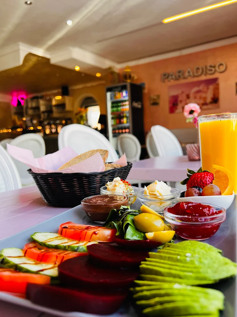 Frühstücksteller mit Brotkorb, Dips, Avocado, Beeren und frisch gepresstem Orangensaft